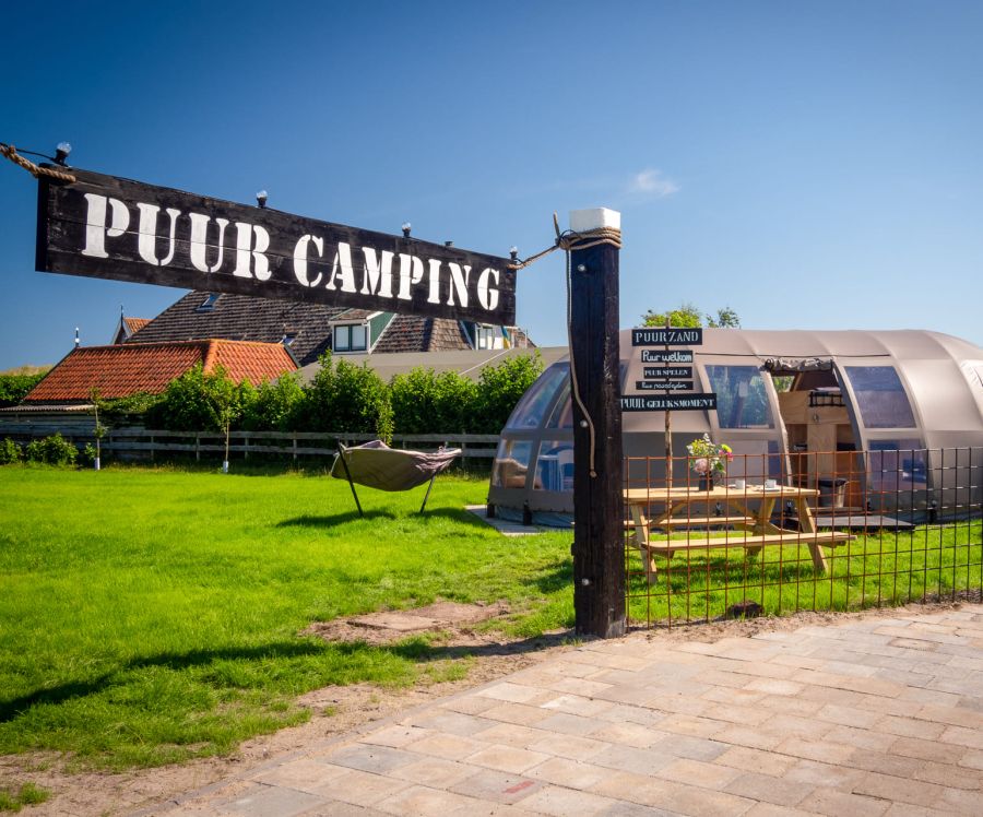Puur Terschelling das Eingangsschild des Campingplatzes mit einem Dünenzelt im Hintergrund